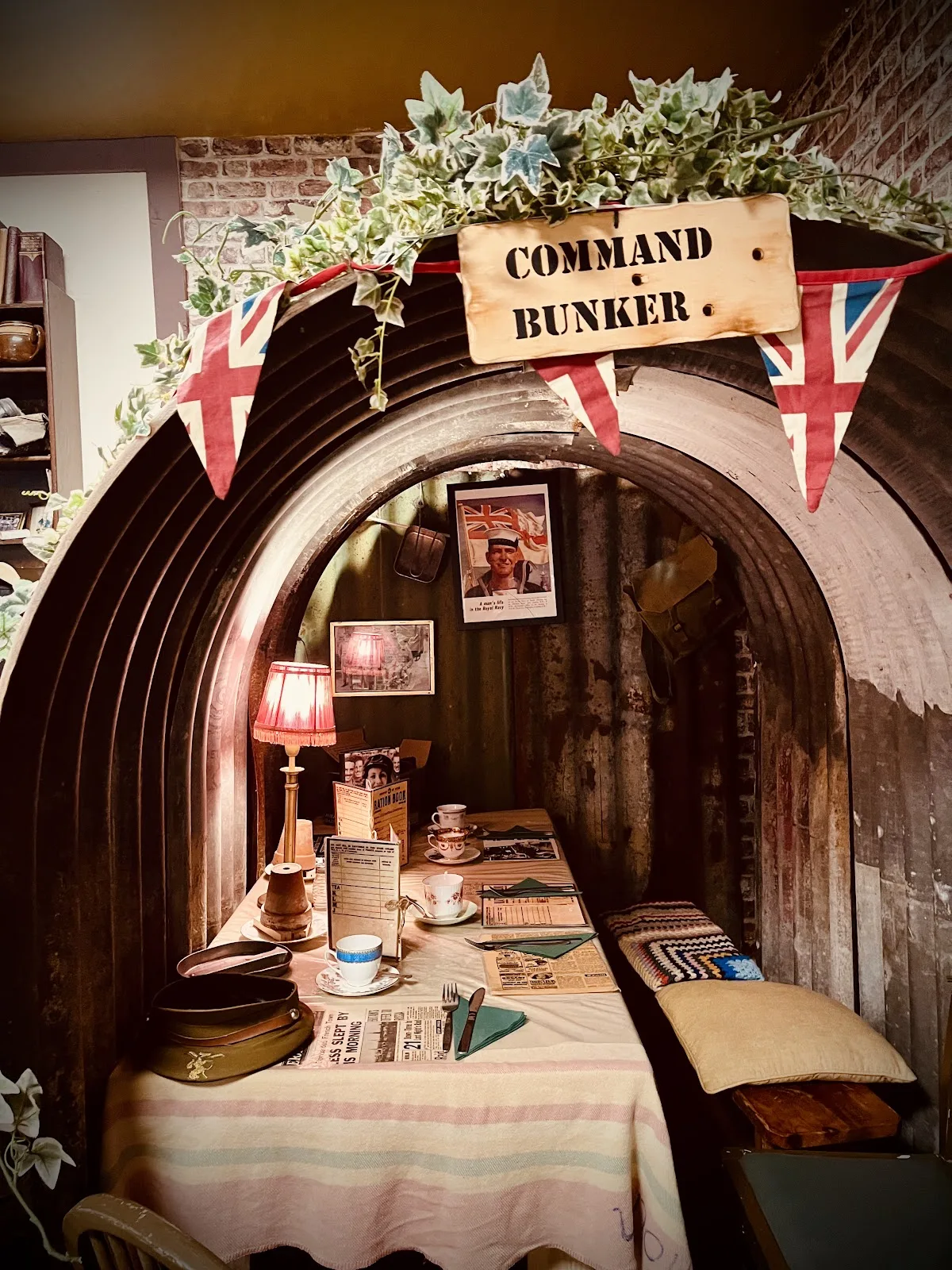 The Command Bunker at 19 Fourteas, a corrugated Anderson shelter with a lamp lit table laid for tea