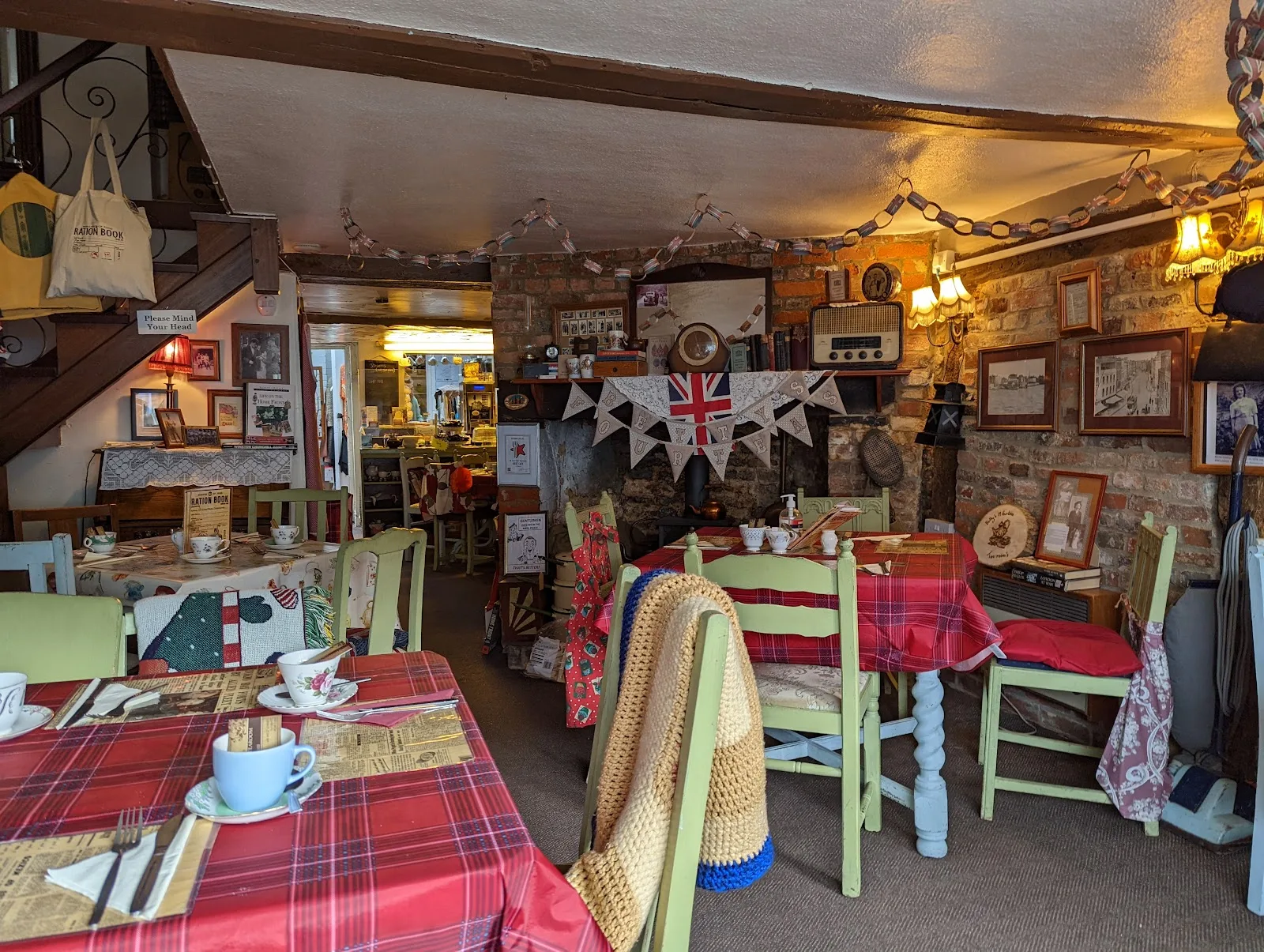 Tartan covered tables, painted chairs and the brick fireplace at 19 Fourteas